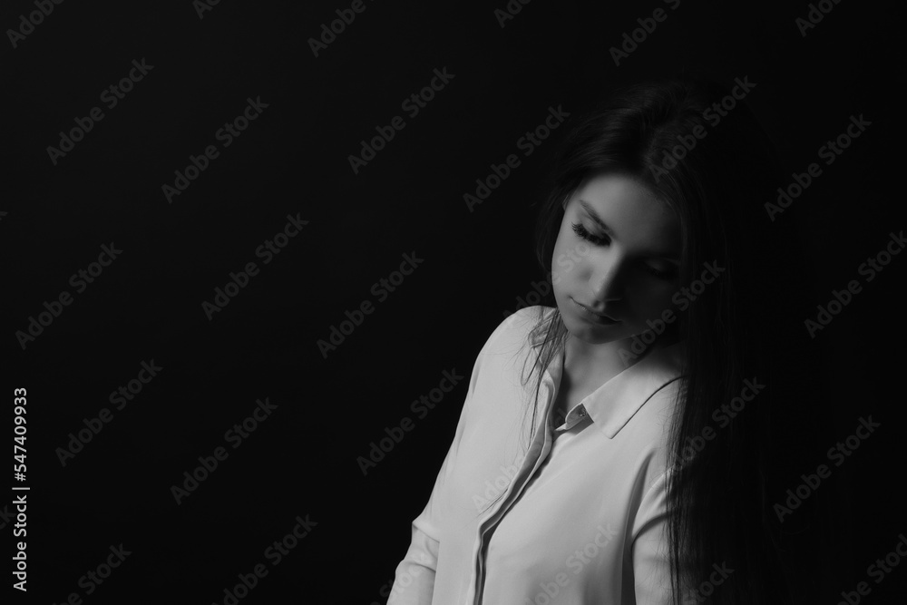 Black and white low key studio portrait of sad girl. Horizontally. Black and white low key studio portrait of sad girl. Horizontally.
