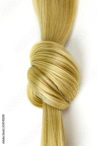 Hairdresser service, blond hair lock tied in knot strength, haircut, hairstyle. Blond wavy hair on white background.