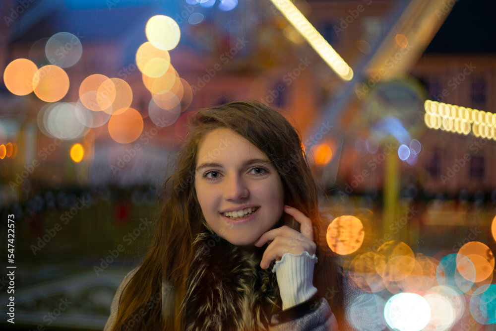 Girl in Christmas traditional market decorated with holiday lights in the evening. Beautiful night with blur lights and colors. Artistic photography with nice blured light bokeh. Girl in Christmas traditional market decorated with holiday lights in the evening. Beautiful night with blur lights and colors. Artistic photography with nice blured light bokeh.