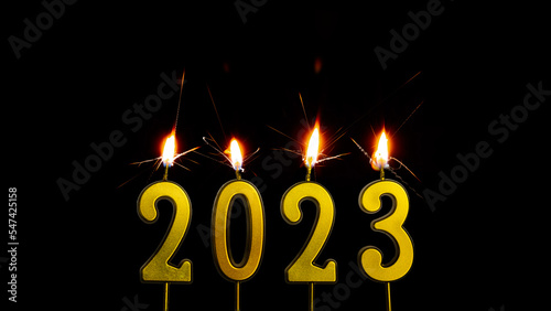 Holiday background Happy New Year 2023. Numbers of the year 2023 made by gold sparkler candle number. celebrating New Year's holiday.isolated on black background 