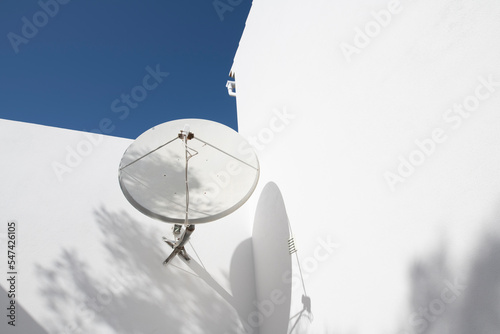 TV Satellite dish on the wall of a white house
