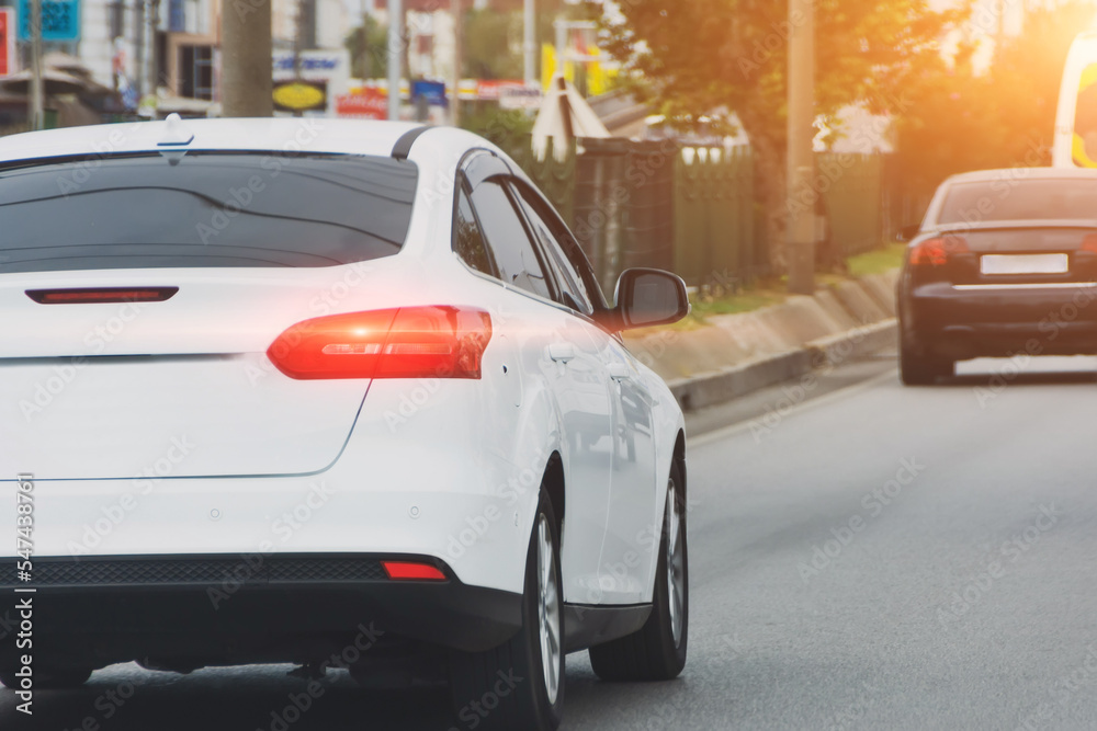 White car is chasing another dark one on a city road. White car is chasing another dark one on a city road.