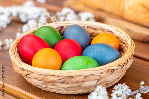 Easter eggs, dyed hen eggs in a wicker basket bowl