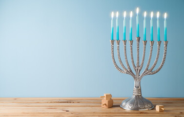 Jewish holiday Hanukkah background with menorah and candles on wooden table.