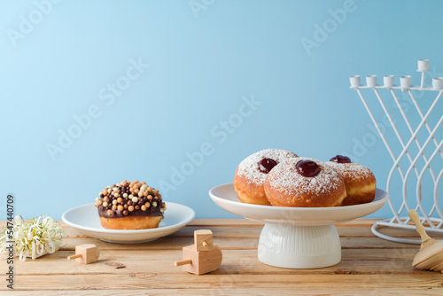 Traditional donuts for Hanukkah holiday celebration on wooden table photo
