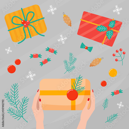 Womens hands are packing a gift on the table, top view. Process of Wrapping christmas gift boxes
