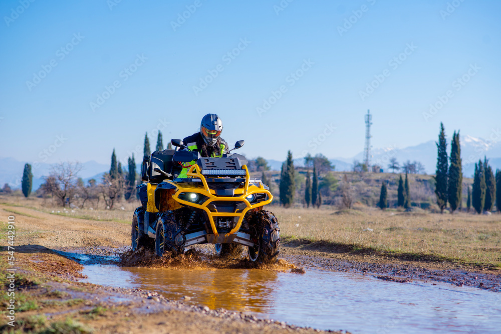 Fototapeta premium Girl driving ATV on dirt road