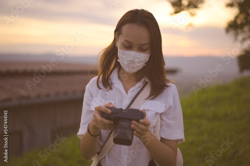 Young woman checking her camera in golden hour