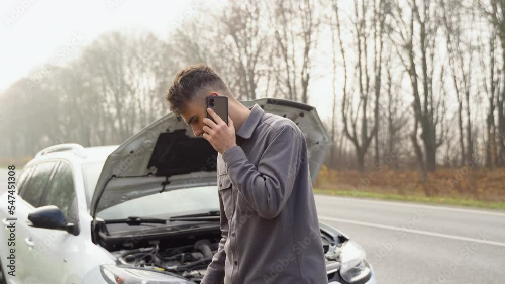 Sad man standing speak on phone near the broken car opened the hood road help repair stress problem emergency insurance auto slow motion. Transportation, traveling concept Sad man standing speak on phone near the broken car opened the hood road help repair stress problem emergency insurance auto slow motion. Transportation, traveling concept