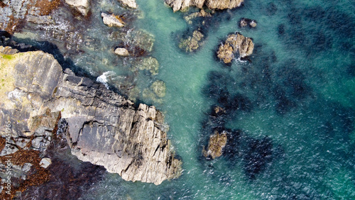 A lot of boulders in the sea water. Coastal cliffs of the North Atlantic. Seaside beautiful nature. Dramatic seascape of the north of Europe. Drone photo. View from above.