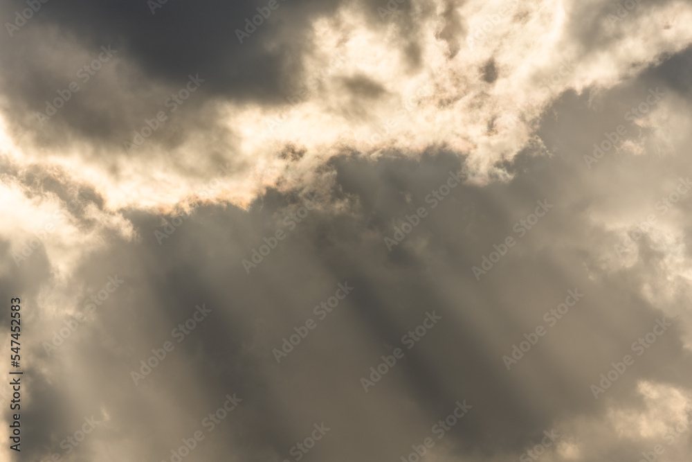 Beams of light of sun's rays through clouds in morning.