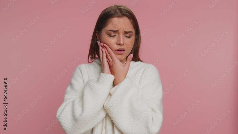 Hipster young woman touching sore cheek suffering from toothache cavities or gingivitis waiting for dentist appointment gums disease. Adult girl indoors studio shot isolated alone on pink background Hipster young woman touching sore cheek suffering from toothache cavities or gingivitis waiting for dentist appointment gums disease. Adult girl indoors studio shot isolated alone on pink background