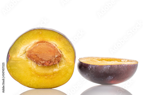 Two halves of a ripe plum, close-up, isolated on a white background.