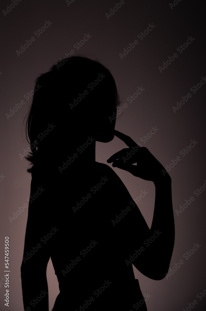Silhouette of a pensive girl on a gray background. Silhouette of a pensive girl on a gray background.