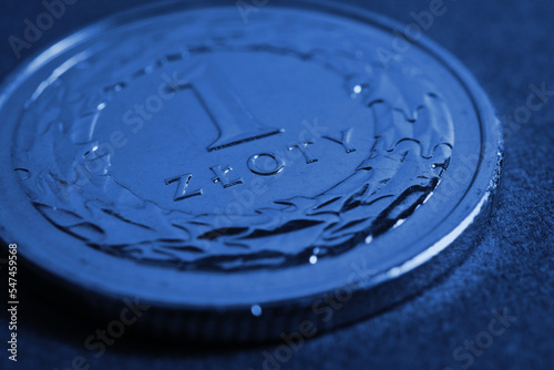 Translation  1 zloty. Polish one zloty coin close up. National currency and money of Poland. Dark blue tinted background for news about economy or finance. Macro