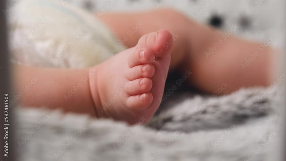 Baby twitches legs while lying on bed. Newborn baby feet together, infant foot first week of life. Sweet Newborn Baby Feet. Tiny Human Feet of Neonate Toddler is in Focus. Concept of Childhood 4k Baby twitches legs while lying on bed. Newborn baby feet together, infant foot first week of life. Sweet Newborn Baby Feet. Tiny Human Feet of Neonate Toddler is in Focus. Concept of Childhood 4k