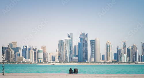 Man sitting in front of city skyline in Doha, Qatar.