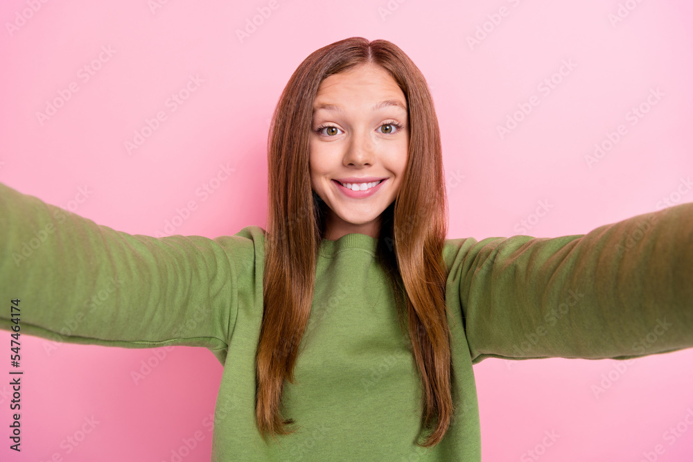 Portrait of nice cute satisfied girl long hairdo dressed green sweatshirt making selfie recording video isolated on pink color background Portrait of nice cute satisfied girl long hairdo dressed green sweatshirt making selfie recording video isolated on pink color background