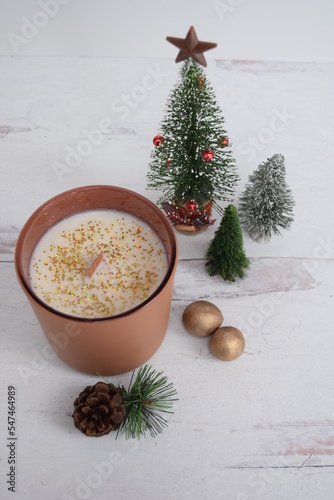 Holiday wood wick candle with gold balls and festive trees. 