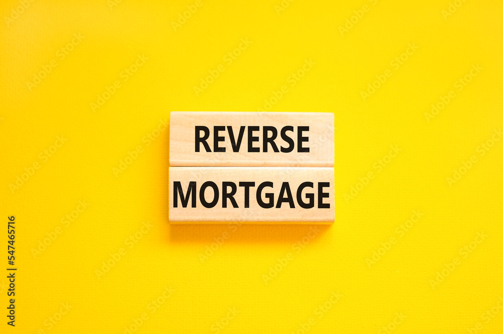 Reverse mortgage symbol. Concept words Reverse mortgage on wooden blocks. Beautiful yellow table yellow background. Business and reverse mortgage concept. Copy space. Reverse mortgage symbol. Concept words Reverse mortgage on wooden blocks. Beautiful yellow table yellow background. Business and reverse mortgage concept. Copy space.
