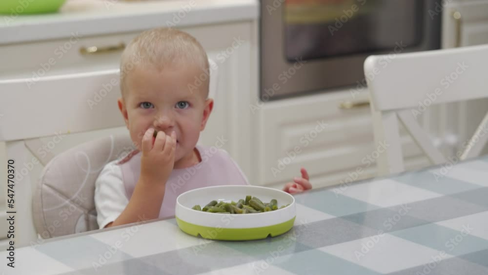 Child does not want to eat breakfast. Toddler boy eating cut and cooked green beans. Child does not want to eat breakfast. Toddler boy eating cut and cooked green beans.