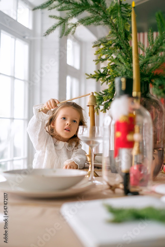 Canvas-taulu The cute girl is focused on extinguishing the candle fire