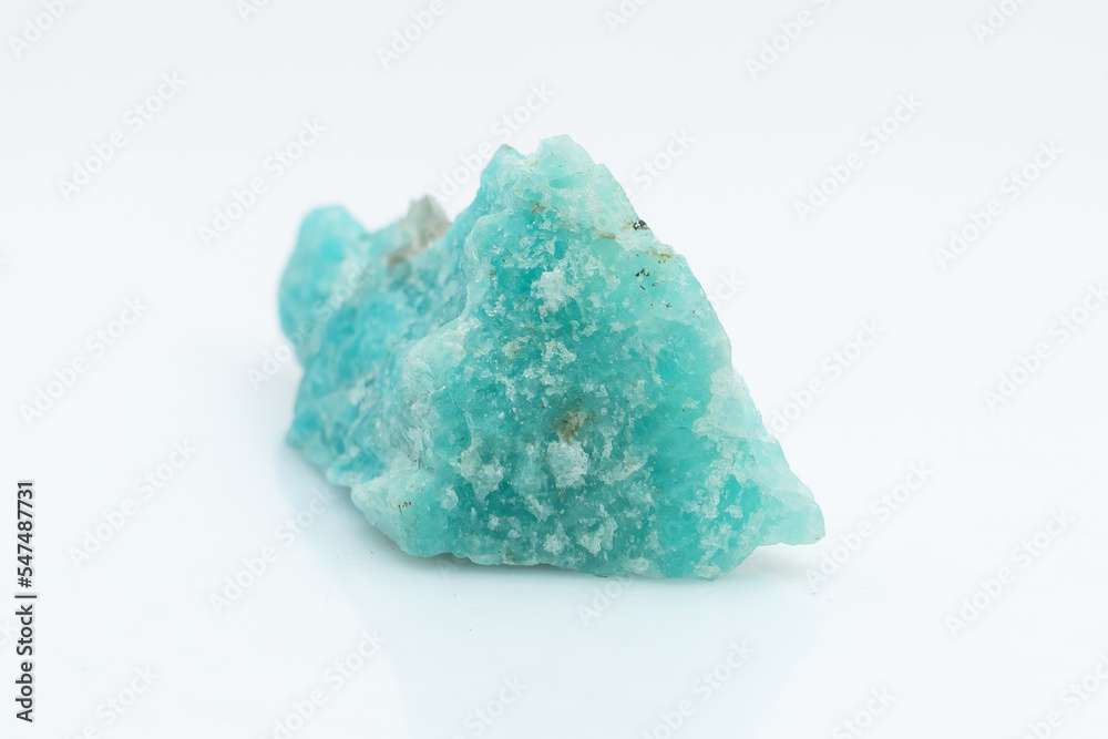 Natural amazonite gemstone isolated on white background. A bluish-green crystal on a white background. A variety of potassium feldspar microcline Natural amazonite gemstone isolated on white background. A bluish-green crystal on a white background. A variety of potassium feldspar microcline
