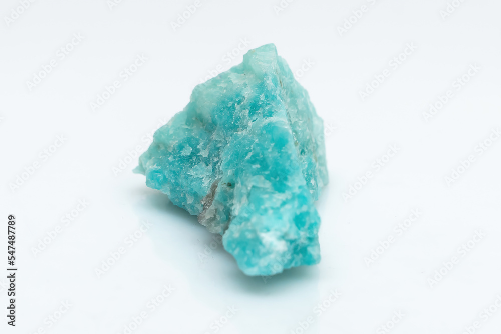 Natural amazonite gemstone isolated on white background. A bluish-green crystal on a white background. A variety of potassium feldspar microcline