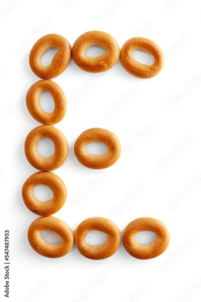 Letter E bagel. Bagels font. Alphabet from set of small dry bagels isolated on white background. ABC symbols. Letter E bagel. Bagels font. Alphabet from set of small dry bagels isolated on white background. ABC symbols.