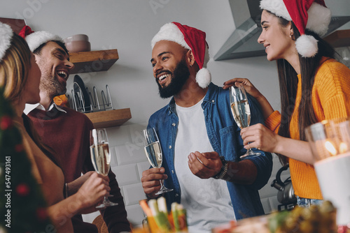 Happy young people communicating while enjoying Christmas dinner at home