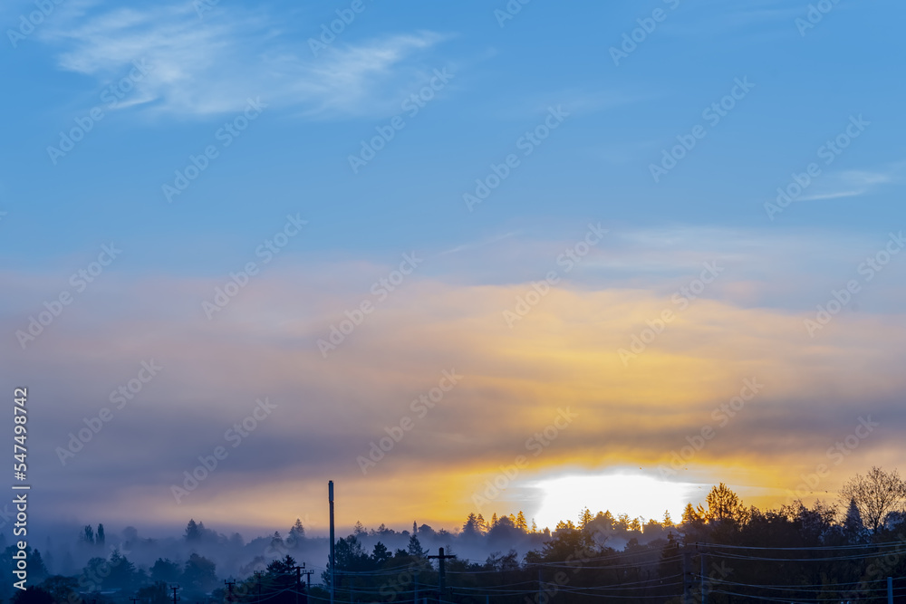 Morning fog at sunrise over a European provincial town against the sky.