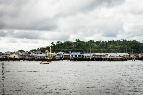 Landscape view of the buildings in the water village with boats nearby on a clouded day photo