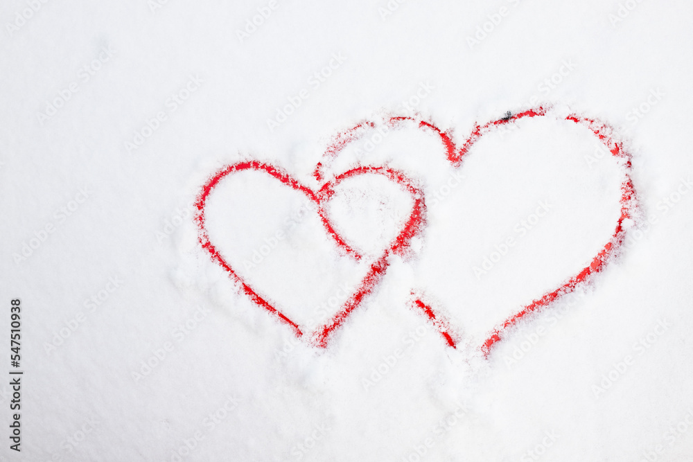 Two hearts symbol of love hand drawing painted on snow on the red car. Valentines day, love, honeymoon, winter, transport concept. Copy space.