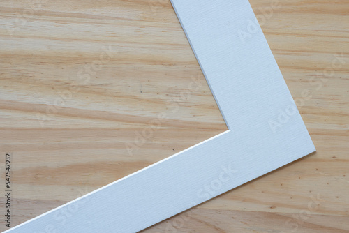 detail of white picture mat board on wood