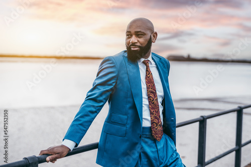 Stampa su tela A portrait of a fashionable manly bald bearded black man entrepreneur in a blue