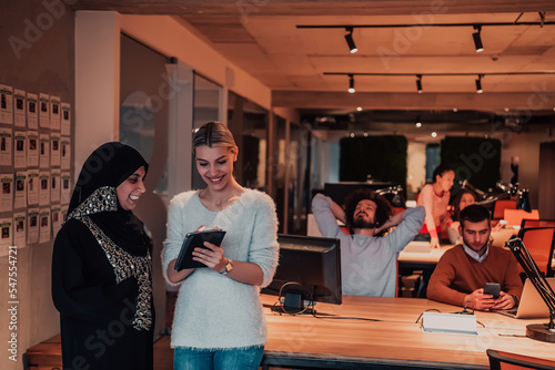 Muslim businesswoman woman and young businesswoman in a modern office solve a problem together while using a tablet