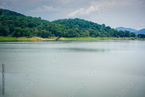 View of the jatiluhur reservoir with a wide expanse of water and full of green forest mountains in Purwakarta Regency, West Java, Indonesia