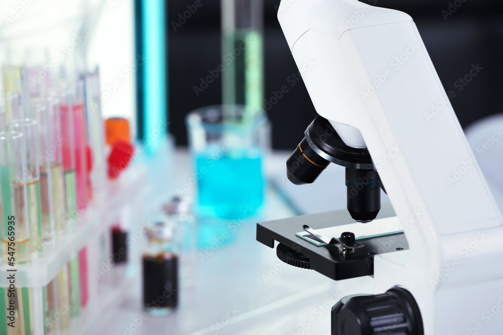 Modern microscope with glass slide in laboratory, closeup. Space for text Modern microscope with glass slide in laboratory, closeup. Space for text