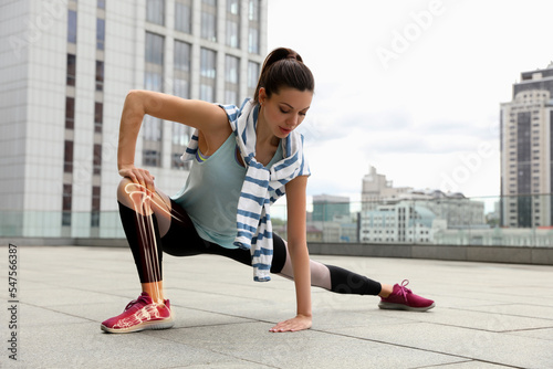 Digital composite of highlighted bones and woman doing fitness exercise outdoors