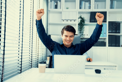Photography Young male employee receives a promotion, good news or finished his task and overjoyed for being a competent worker