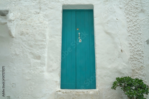 Rough white wall with door in blue color