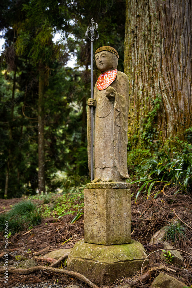 Old budda monk statue in the temple forest in Japan