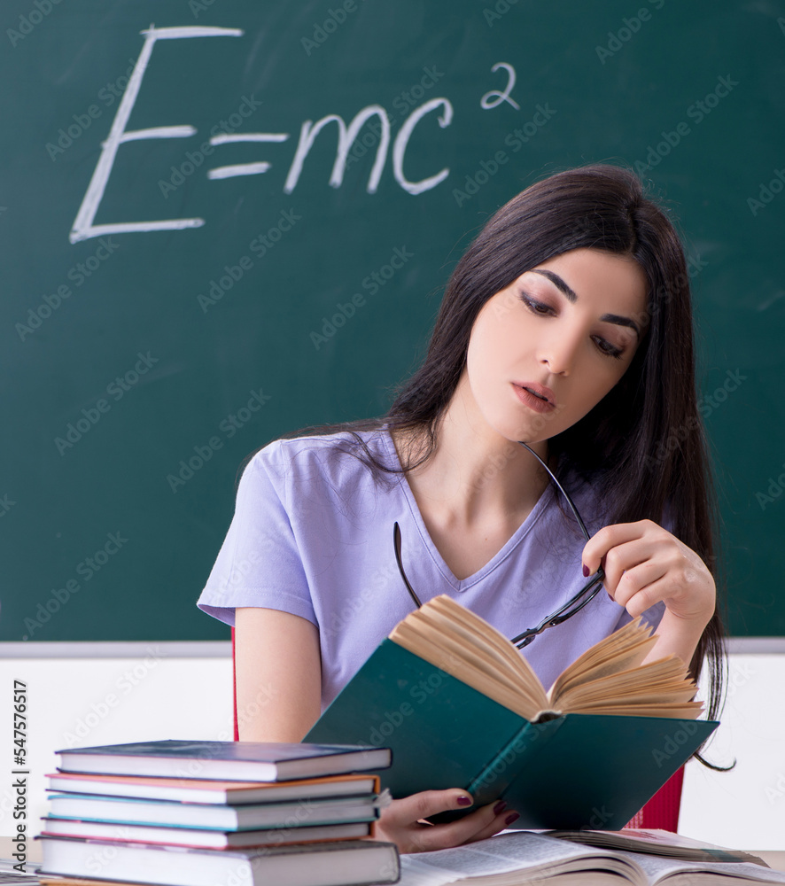 Young female teacher student in front of green board Young female teacher student in front of green board