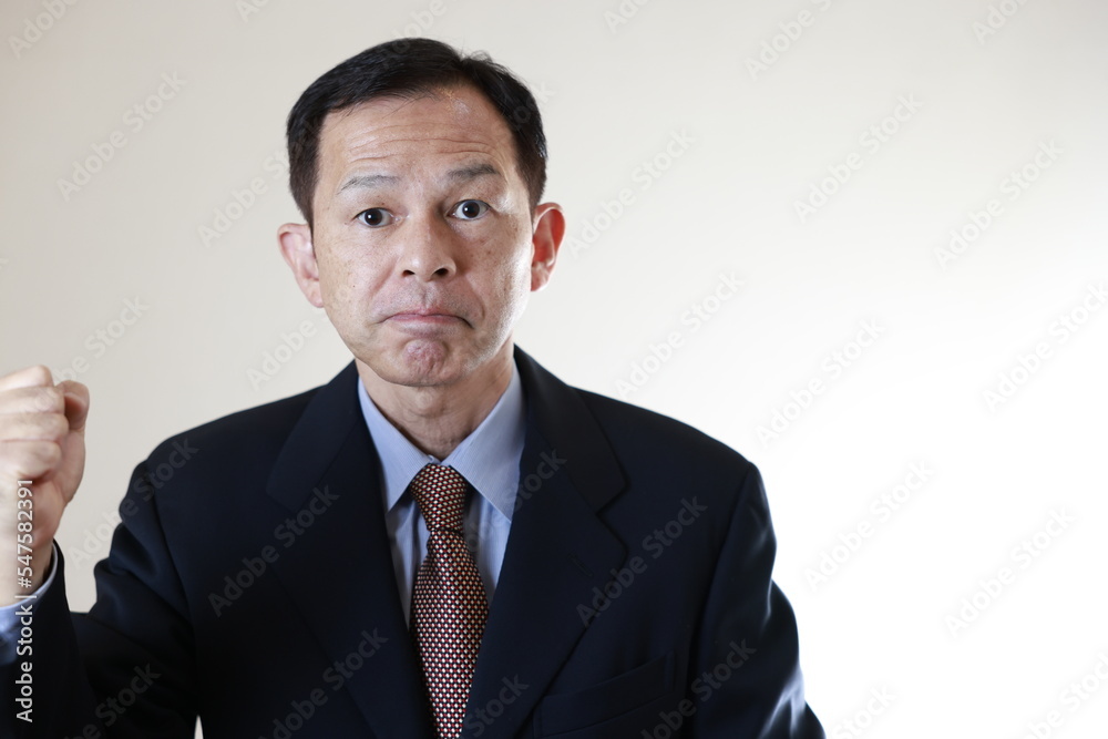 Middle-aged Japanese male businessman wearing navy blue suit on white background holding tablet PC. Conceptual image of a project proposal, strategic business success and negotiation closing. Middle-aged Japanese male businessman wearing navy blue suit on white background holding tablet PC. Conceptual image of a project proposal, strategic business success and negotiation closing.