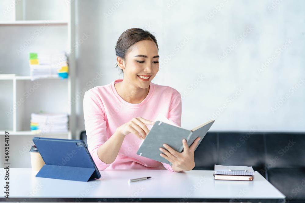 Asian woman working online with tablet Happy young woman working from home Asian woman working online with tablet Happy young woman working from home