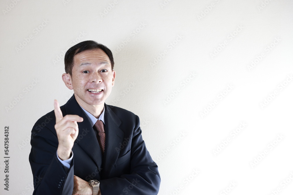 Middle-aged Japanese male businessman wearing navy blue suit with hands folded on white background. Conceptual image of a project proposal, strategic business success and negotiation closing. Middle-aged Japanese male businessman wearing navy blue suit with hands folded on white background. Conceptual image of a project proposal, strategic business success and negotiation closing.