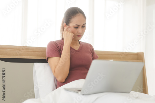 Asian woman using laptop on bed for telemedicine mental health online therapy