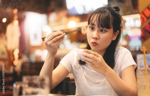 Portrait of young adult asian woman eating japan culture food in izakaya japanese restaurant