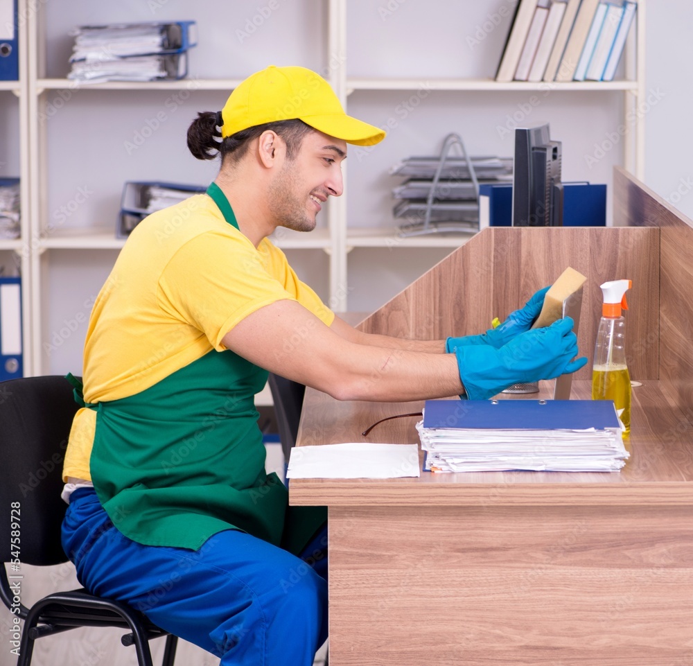 Young male contractor cleaning the office Young male contractor cleaning the office