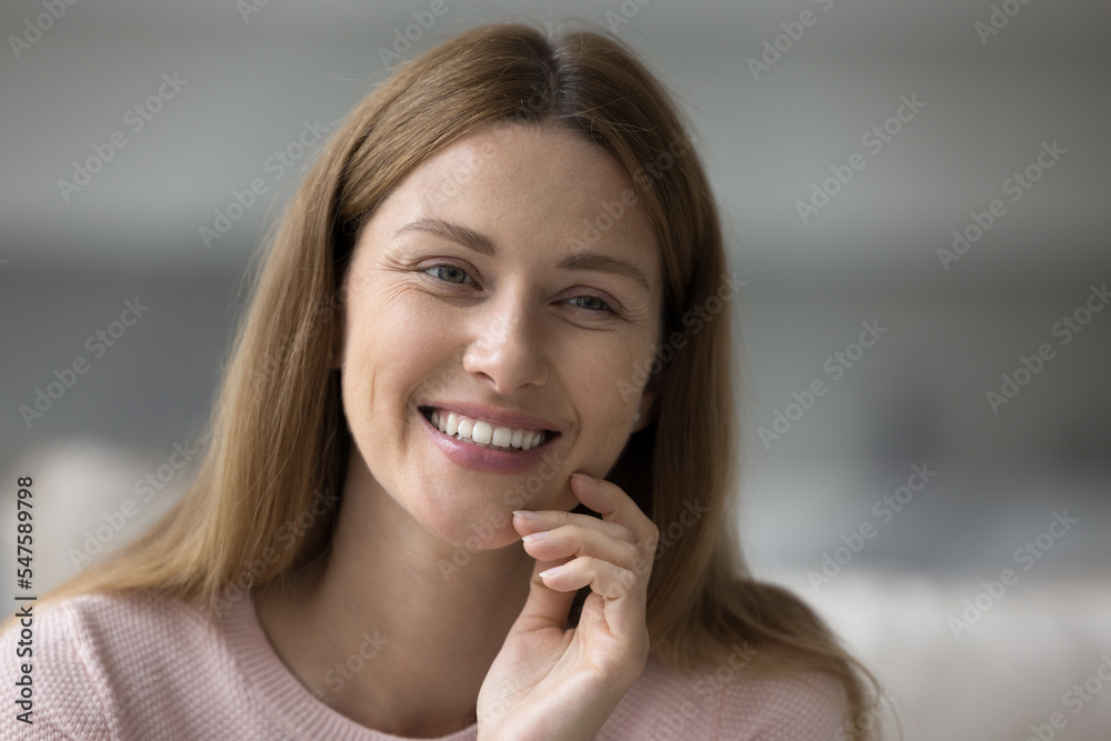 Close up portrait pretty woman sitting indoors staring aside. Natural beauty, female face with non-make up, looks deep in thoughts, feels happy, having charming white-toothed smile and perfect skin Close up portrait pretty woman sitting indoors staring aside. Natural beauty, female face with non-make up, looks deep in thoughts, feels happy, having charming white-toothed smile and perfect skin